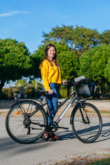 Obraz premium Woman with bike and headphones in the park.