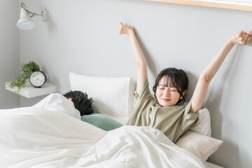 熟睡・快眠して気持ちよく目覚める妻・女性（起床・寝起き・睡眠）
