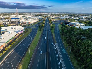 Obraz premium High-angle view of a highway with traffic, commercial buildings, and shopping centers. Urban sprawl and transportation infrastructure. MT WELLINGTON, AUCKLAND, NZ