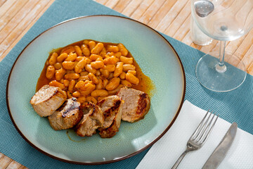 Pieces of delicious pork with beans on a plate
