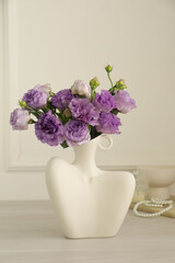 Stylish vase with beautiful flowers and decor on white wooden table at home