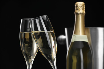 Champagne in glasses and bottle on black background, closeup