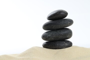 Stack of rocks on sand against white background, space for text. Harmony and life balance