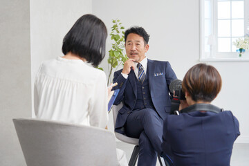 ビジネスマンにインタビューする女性記者