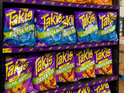 Bags of Takis brand snacks for sale at a supermarket shelf. Takis are a Mexican brand of flavored rolled tortilla chips produced by Barcel