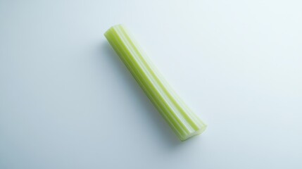 Fototapeta premium 106.A single celery stalk with its intricate ridges and fresh green hues, captured in sharp focus on a pure white surface for a clean presentation.