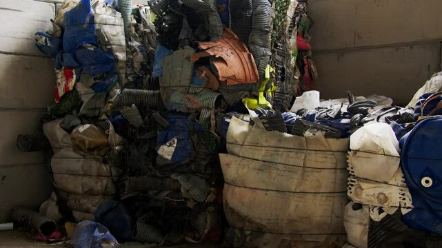 Footage of used clothes and Plastic trash in a recycle facility
