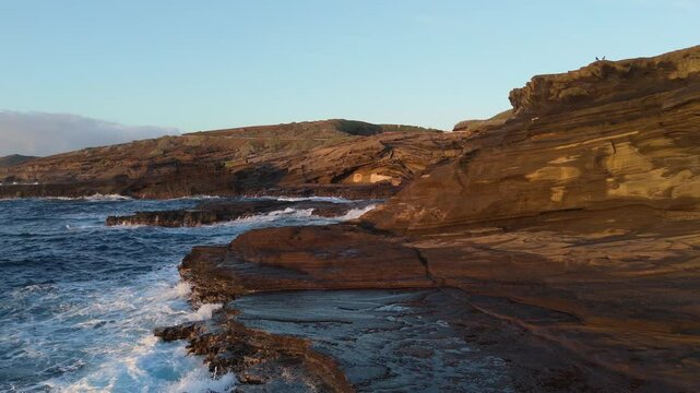 Aerial view of waves crashing on rocks shore in Hawaii