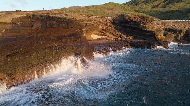 Aerial view of waves crashing on rocks shore in Hawaii