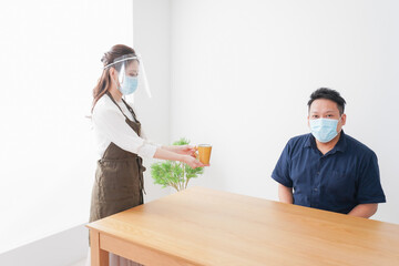 コロナウイルスの予防を徹底するカフェスタッフ
