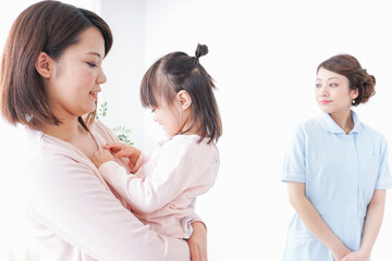 Naklejka premium 病院で診察を受ける子どもとお母さん