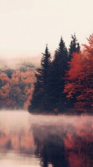 Serene autumn landscape reflecting vibrant foliage in calm lake surrounded by misty hills