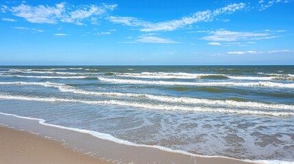 Serene beach scene with gentle waves lapping at the shore under a clear blue sky