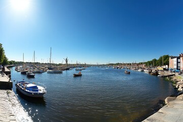 Scenic River View with Boats and Clear Blue Sky in Coastal Town