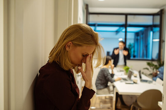Stressed woman in office during tense business meeting