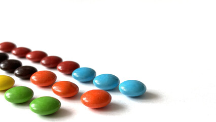 Multicolored round candies on white background, close-up with space for text banner