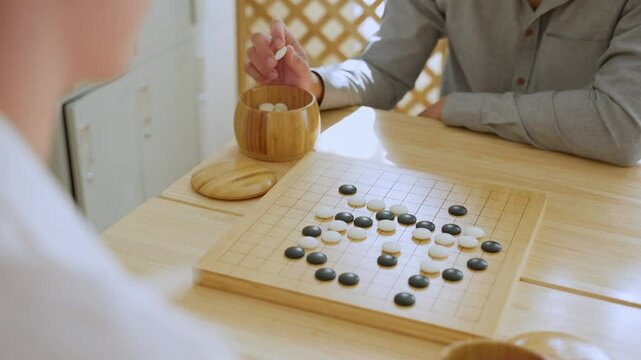 Close up of young men play board game Go during competition in community.