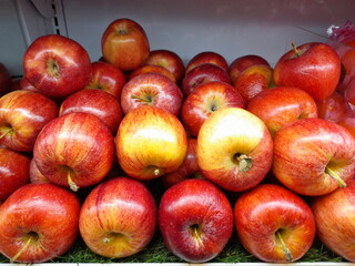 Ripe red apples at the market. Natural red background. A group of red apples on display