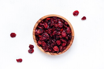 Organic sun dried cranberries in bowl on white background, top view