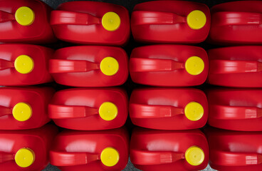 Top view of arranged red plastic motor oil bottles, containers with handle and yellow screw cap