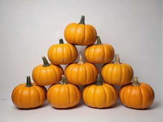 Obraz premium Ten Pumpkins Arranged in a Triangle on White Background