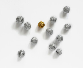 Crumpled silver and golden aluminum foil spheres on white background, isolated with copy space, top...