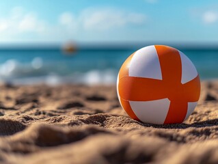 Obraz premium Beach ball rests on sand, ocean background, summer fun