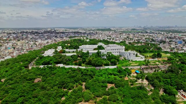 Hyderabad city aerial view with taj falaknuma palace, greenery, trees, and clouds at engine bowli, falaknuma, hyderabad, telangana, india. day time, semi circle, drone shot, 4k.