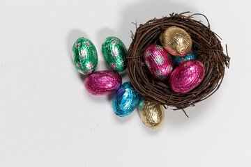 chocolate easter eggs in a nest isolated against white with copy space.