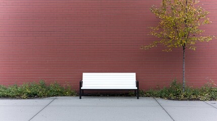 Empty white park bench against red brick wall