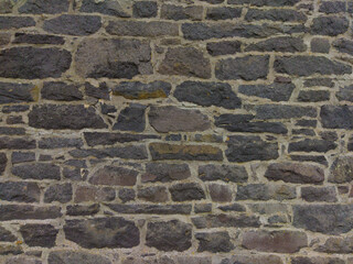 An old stone wall. Brickwork. Background of grey stones. The texture of the stone. Horizontal image.