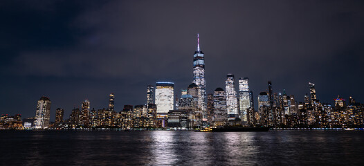 Fototapeta premium NYC night skyscrapers. Manhattan at sunset. NY cityscape with lights. Night in New York. NYC night cityscape. Downtown Manhattan. New York at twilight. American city. New York City skyline.