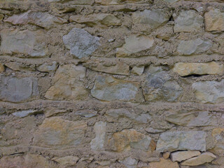 An old grey stone wall. Grey stone background. The texture of the stone.