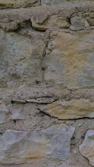 An old grey stone wall. Grey stone background. Vertical image. Stone texture.