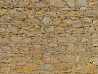 The old yellow stone wall. Yellow stone background. Stone texture. Masonry.