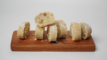 Cranberry cream cheese bread that has been cut into small pieces placed on wood plate isolated on a white background 