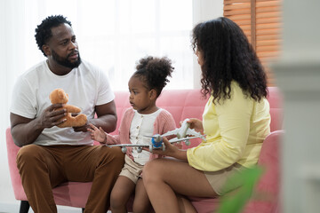 Happy diverse family concept. African American father, mother and cute daughter playing together at home. Small family spending time together at home. Father, mother, daughter and family concept