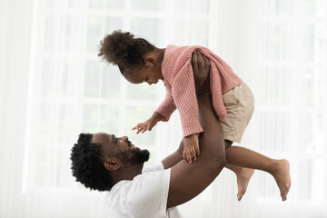 African American father and cute daughter playing together at home. Adult father and little girl...
