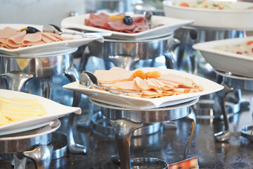 Buffet display featuring assorted cold cuts and salads in a restaurant