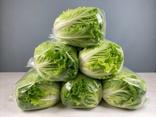 Fototapeta premium Pyramid of Fresh Napa Cabbage in Plastic Bags
