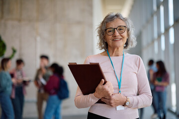 Happy mature professor at university looking at camera.
