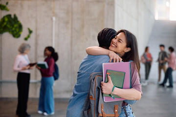 Happy college couple embracing in hallway.