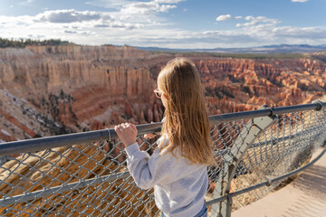 Child standing at hoodoo on top of mountain looking at beautiful view. Bryce Canyon National Park, Utah, USA.