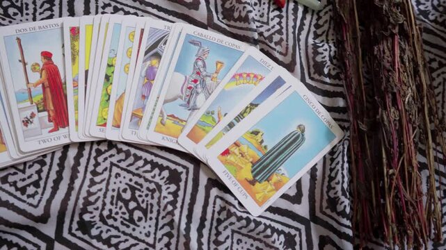 Tarot cards, highlighting the symbolic Five of Cups and Two of Wands on a beautifully patterned black-and-white fabric. It evokes themes of divination, mysticism, spiritual reflection, and esoteric 