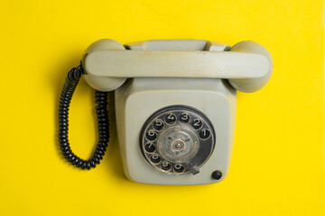 Retro phone on yellow background. Vintage phone on yellow background top view.