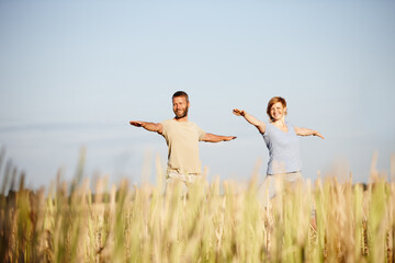 Fitness, stretching and yoga with couple on blue sky together for holistic health or wellness routine. Balance, exercise or smile with man and woman in corn field for awareness or mindfulness