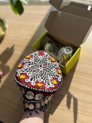 Arab ethnic headwear decorated and embroidered with intricate patterns against an open cardboard...