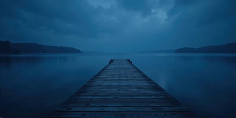 Fototapeta premium Serene Twilight A Wooden Dock Extends into a Calm, Dark Blue Lake, Surrounded by Silhouetted Trees under a Cloudy Sky