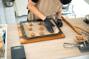Baker preparing chocolate chip cookie dough on a baking tray