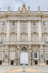 Madrid, Spain - october 02, 2024: Facade of the Royal Palace of Madrid with tourists walking around in Madrid, Spain